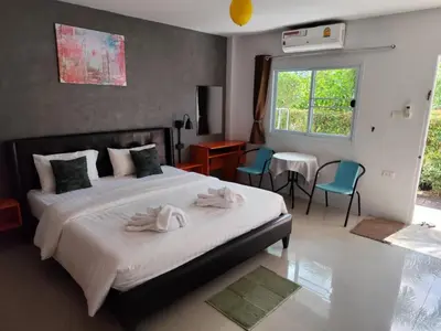 a bedroom with a bed with two towels on it at Bangtao Mango House in Bang Tao Beach