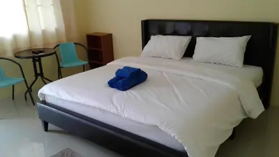a bed with a blue stuffed animal sitting on it at Bangtao Mango House in Bang Tao Beach
