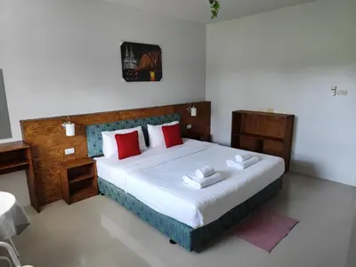 a bedroom with a large bed with red pillows at Bangtao Mango House in Bang Tao Beach