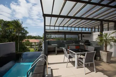 a patio with a table and chairs next to a swimming pool at Aqua A1 in Rawai Beach