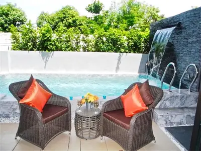 a patio with two chairs and a table and a fountain at COCO Chalong 2 bedrooms New Villa in Chalong