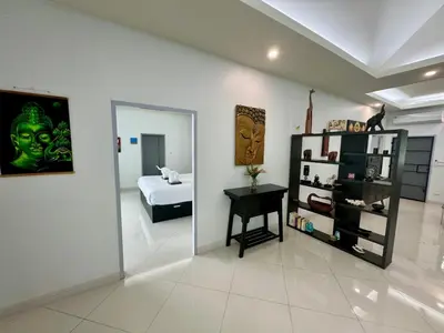 a room with a bed and a table and a mirror at Gabriel Villa by G Estate in Rawai Beach
