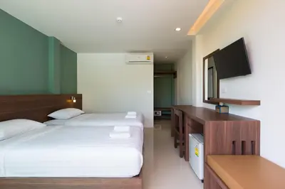 a bedroom with two beds and a flat screen tv at Parida Resort in Bang Tao Beach