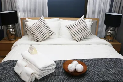 a bed with white towels and a tray of eggs on it at Baan Mai Khao in Mai Khao Beach