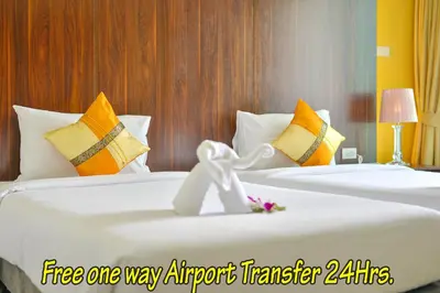 two white beds in a hotel room with at Naiyang Place - Phuket Airport in Nai Yang Beach