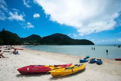 a group of boats sitting on a beach at Twin Palms Hostel Phi Phi in Phi Phi Don