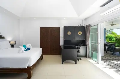 a bedroom with a bed and a desk and a piano at La Romanee Infinity by G Estate in Rawai Beach