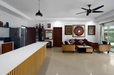 a kitchen and living room with a ceiling fan at Corton Villa by G Estate in Rawai Beach