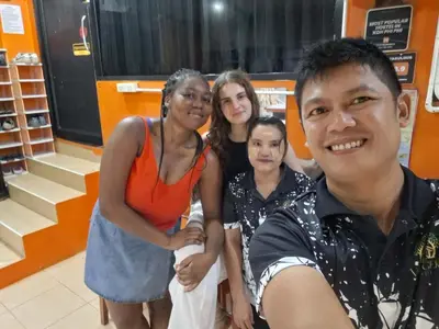 a group of people posing for a picture in a store at Voyagers Hostel in Phi Phi Don
