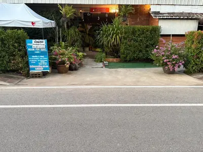 a sign on the side of a street with plants at Krabi Nemo House in Ao Nang Beach