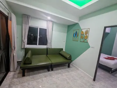 a living room with a green couch and a bed at Nemo 2 Resort in Ao Nang Beach