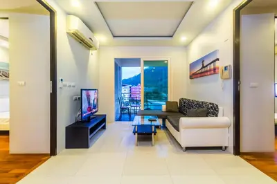 a living room with a couch and a tv at Heaven Lagoon Condo by Lofty in Patong Beach