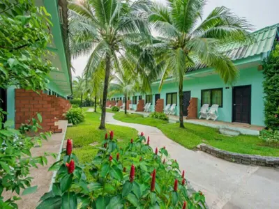 a resort with palm trees and a pathway at Baantonsai Garden Resort in Patong Beach