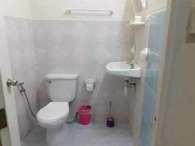 a small bathroom with a toilet and a sink at NB House in Karon Beach