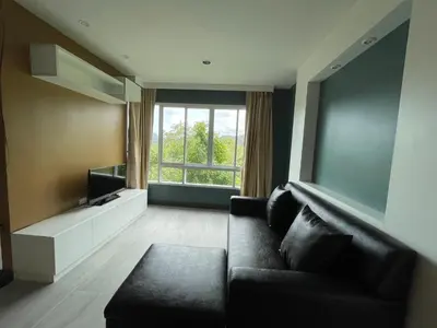 a living room with a couch and a large window at Risa Plus2 in Kathu