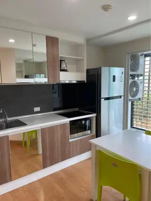 a kitchen with a refrigerator and a table in it at Risa Plus2 in Kathu