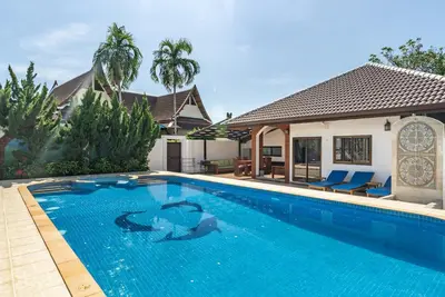 a swimming pool in front of a house at Villa Andre by VillaCarte in Nai Harn Beach