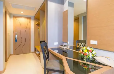 a room with a table with a vase of flowers at AVA SEA Resort Krabi, Ao Nang Beach in Ao Nang Beach