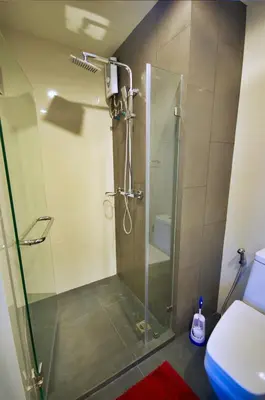 a shower stall in a bathroom with a toilet at 6th Avenue Surin by Risa in Surin Beach