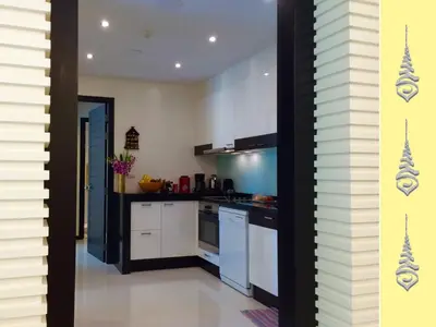 a kitchen with white cabinets and a stove top oven at Apt S104 Kamala Regent in Kamala Beach
