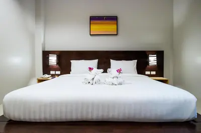 two cats sitting on top of a white bed at S2 Residence in Ao Nang Beach