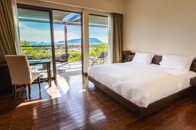 a bedroom with a bed and a table and a balcony at CASABAY Luxury Pool Villas by STAY in Rawai Beach