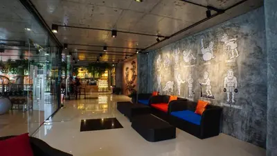 a lobby with couches and paintings on the wall at Maneetel Krabi Beachfront-SHA Plus in Ao Nang Beach