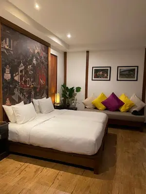 a bedroom with a large white bed with colorful pillows at Tukonnee Villas Koh Yao Noi in Ko Yao Noi