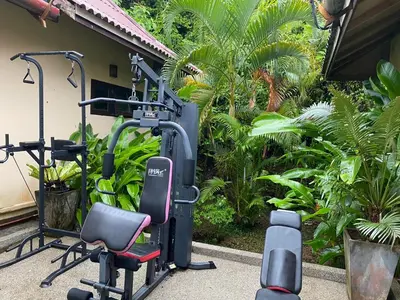 a gym with two exercise bikes next to a building at Tukonnee Villas Koh Yao Noi in Ko Yao Noi