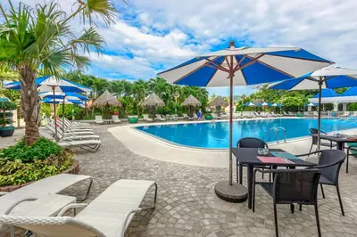 a pool with chairs and tables and umbrellas at Andaman Sea View Apartment - Patong Beach in Patong Beach