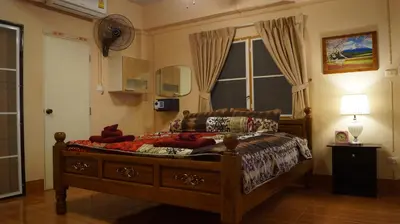 a bedroom with a bed and a window at Kata Apartment in Kata Beach