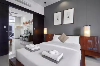 a bedroom with a large white bed with two towels on it at Villa Oxygen - Bangtao Beach in Bang Tao Beach