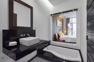 a bathroom with a sink and a mirror and a tub at Villa Oxygen - Bangtao Beach in Bang Tao Beach