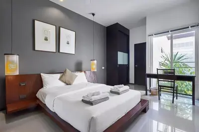 a bedroom with a large white bed and a window at Villa Oxygen - Bangtao Beach in Bang Tao Beach