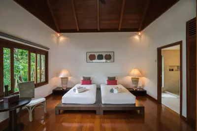 a bedroom with two beds and a table and a mirror at Vichuda Hills by RESAVA in Layan Beach