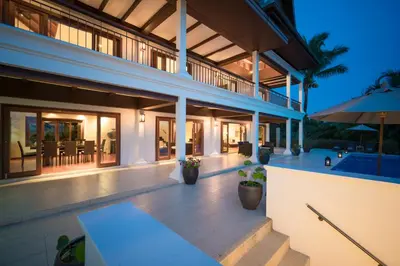 a large house with a patio with an umbrella at Vichuda Hills by RESAVA in Layan Beach