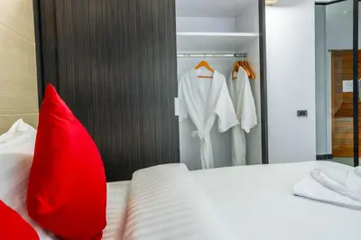 a bedroom with a bed with a red pillow and a closet at The Lucky Beach Ao Nang in Ao Nang Beach