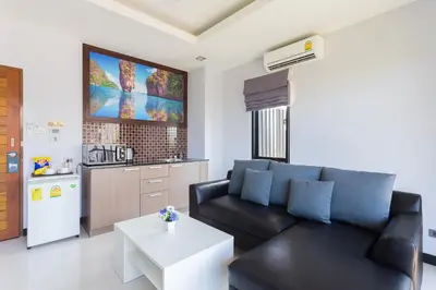 a living room with a black couch and a white table at The Lucky Beach Ao Nang in Ao Nang Beach