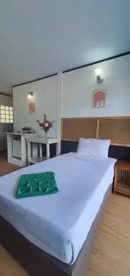 a large white bed with a green blanket on it at Phi Phi View Point Resort in Phi Phi Don