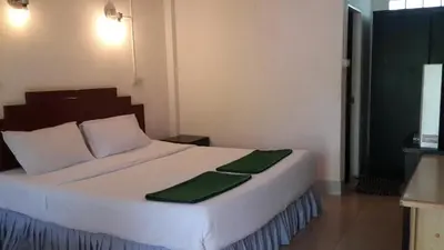a bedroom with a large white bed with green sheets at Phi Phi View Point Resort in Phi Phi Don