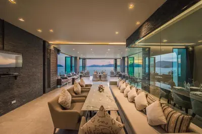 a large room with couches and tables and windows at My Beach Resort Phuket, Panwa Beach in Panwa Beach