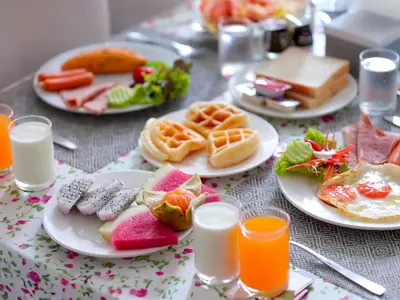 a table with plates of breakfast foods and glasses of orange juice at Phoenix Grand Patong in Patong Beach