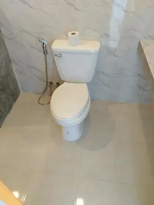 a bathroom with a toilet with a roll of toilet paper on it at Six Pack Cottage in Chalong