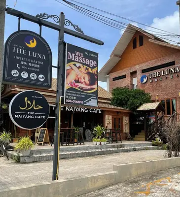 a building with signs in front of a restaurant at The Luna in Nai Yang Beach
