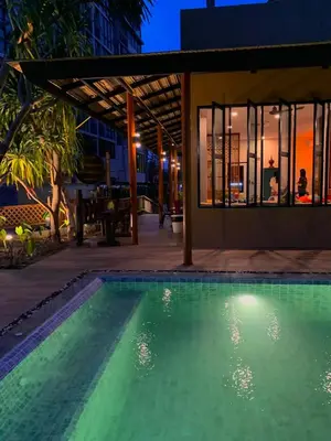 a swimming pool in front of a house at night at The Luna in Nai Yang Beach