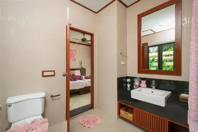 a bathroom with a sink and a toilet and a mirror at Villa Raas 3BR Private PoolNaiharn beach in Nai Harn Beach