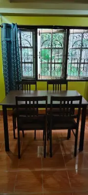 a table and benches in a room with stained glass windows at Baan Asree homestayบ้านอัสรี in Ao Nang Beach