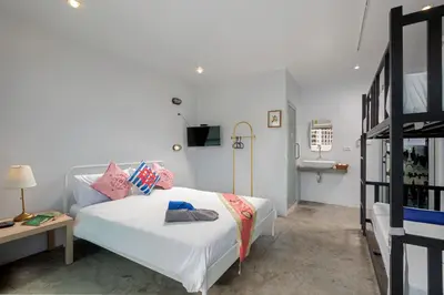 a bedroom with a white bed with pillows on it at Hip Hostel - SHA Plus in Patong Beach