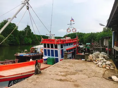 a boat is docked at a dock in the water at Bussarin Mansion Koh Yao Yai in Ko Yao Yai