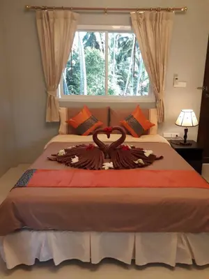 a bedroom with a bed with a large window at Bussarin Mansion Koh Yao Yai in Ko Yao Yai